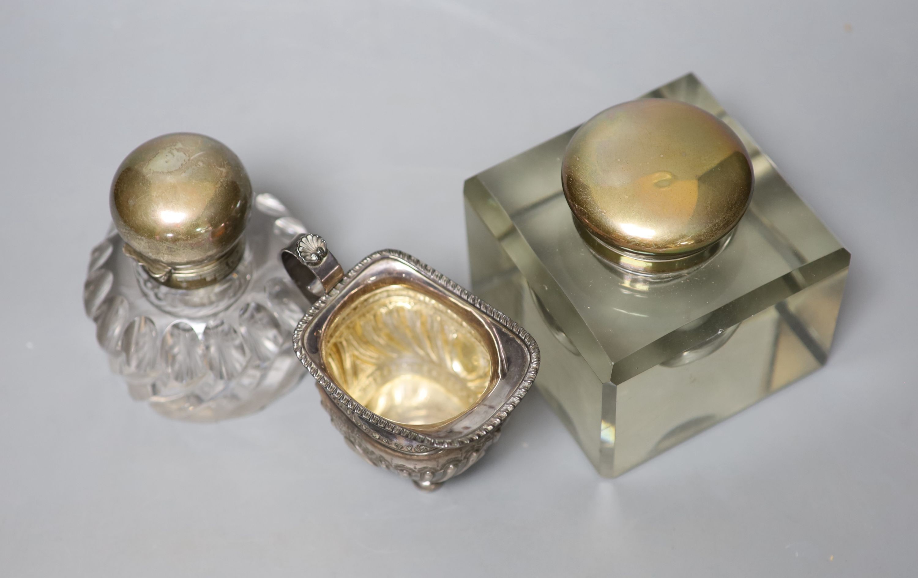 A late Victorian silver cream jug and two silver mounted glass inkwells.